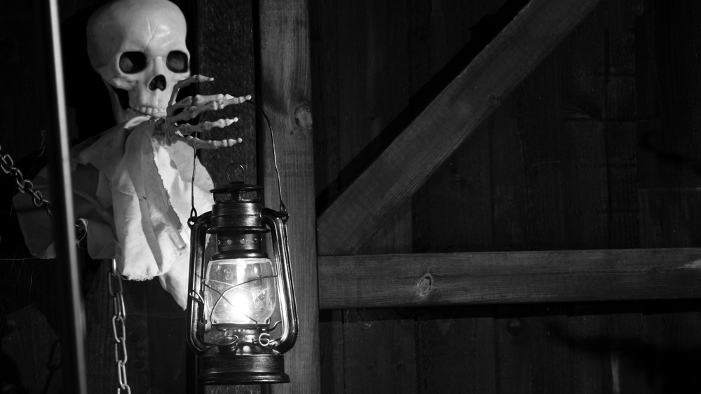 skeleton holding lantern in old building