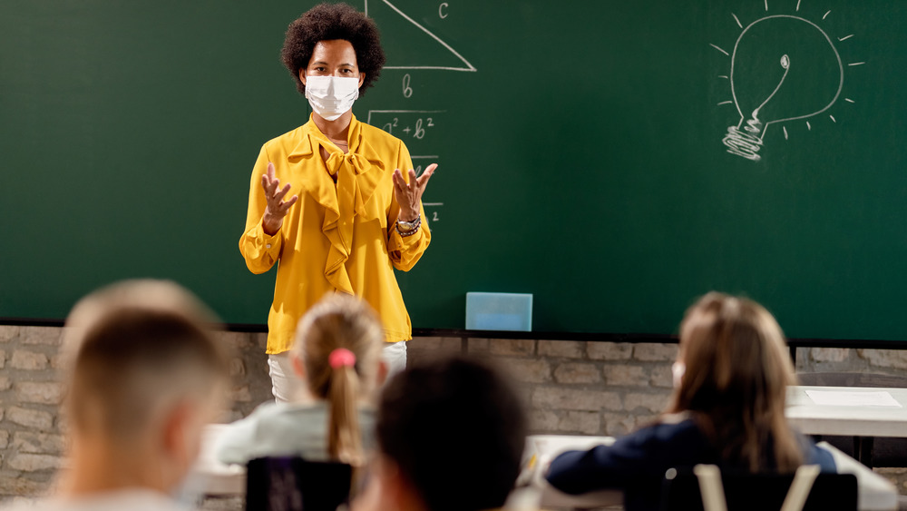 Masked school teacher in classroom