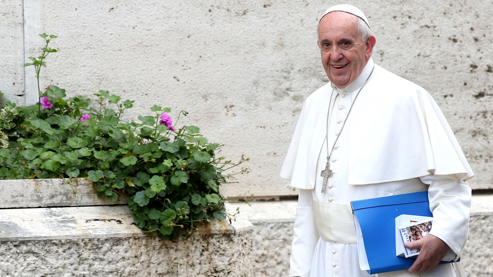 The pope carrying a blue folder