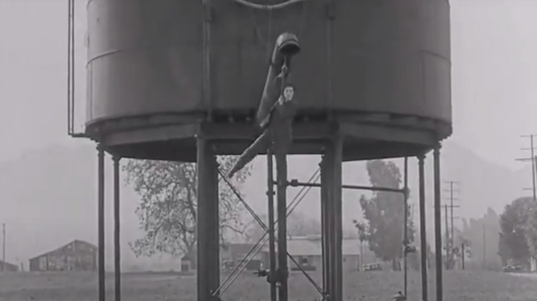 Keaton hanging from a train water tower