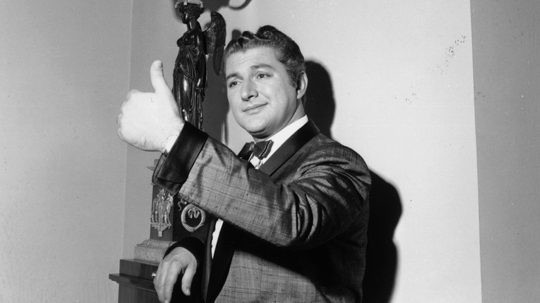 Liberace giving a thumbs up, 1957