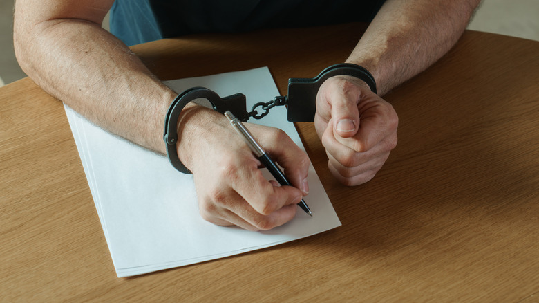 man in handcuffs writing
